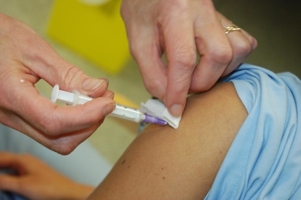 en vaccingeringsspruta förs in i en arm