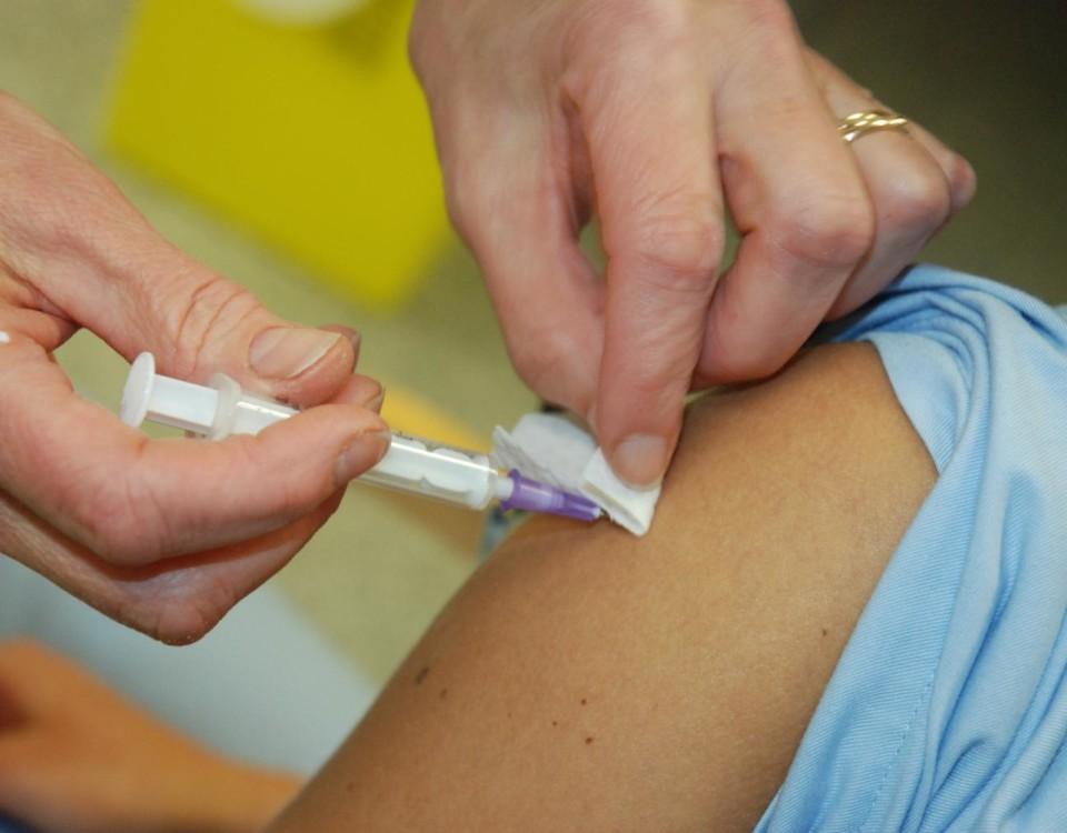 en vaccingeringsspruta förs in i en arm