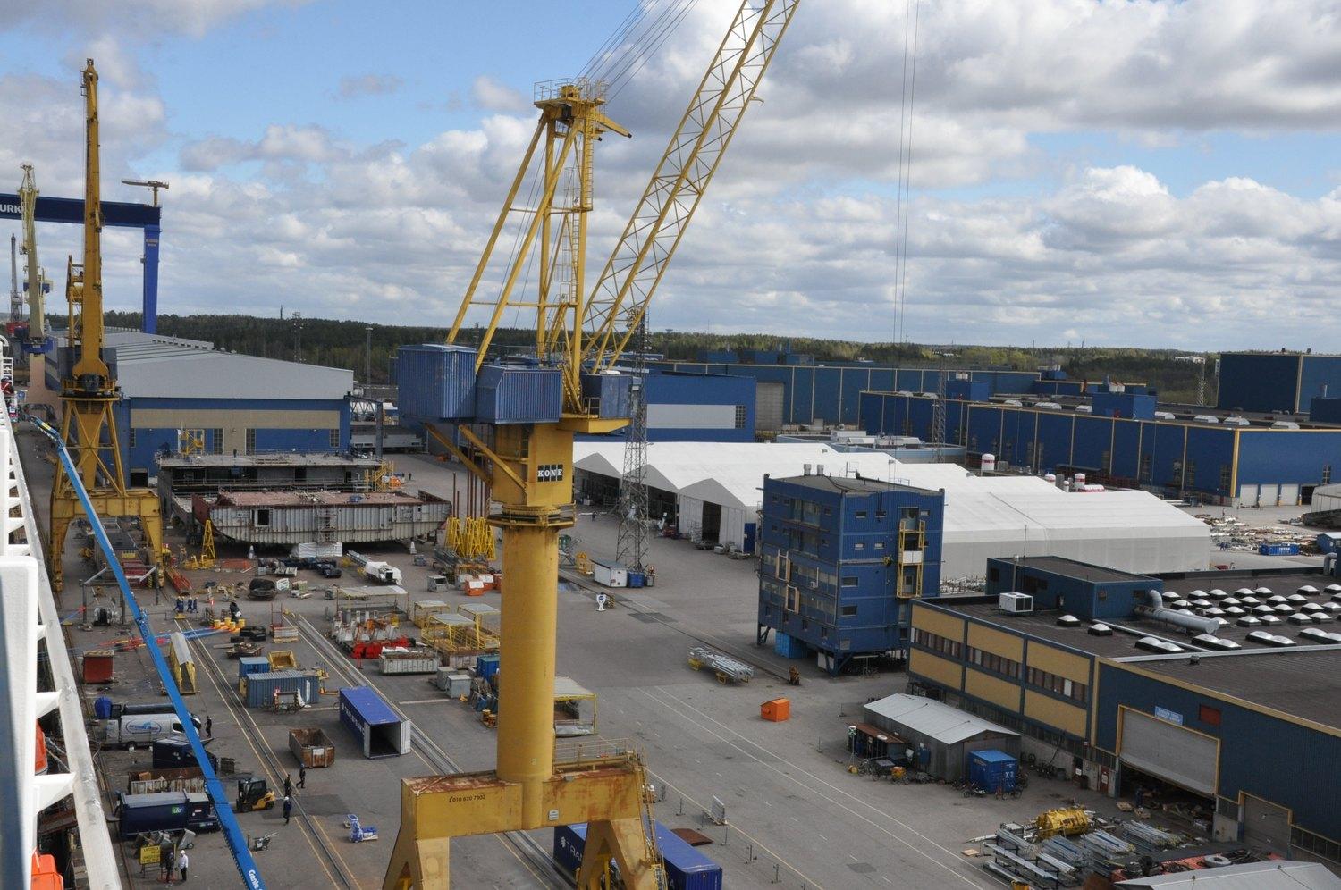 Vy över varvsområdets produktionshallar vid varvet Meyer Turku i Åbo. I förgrunden står en lyfdtkran. lyfkranhft 