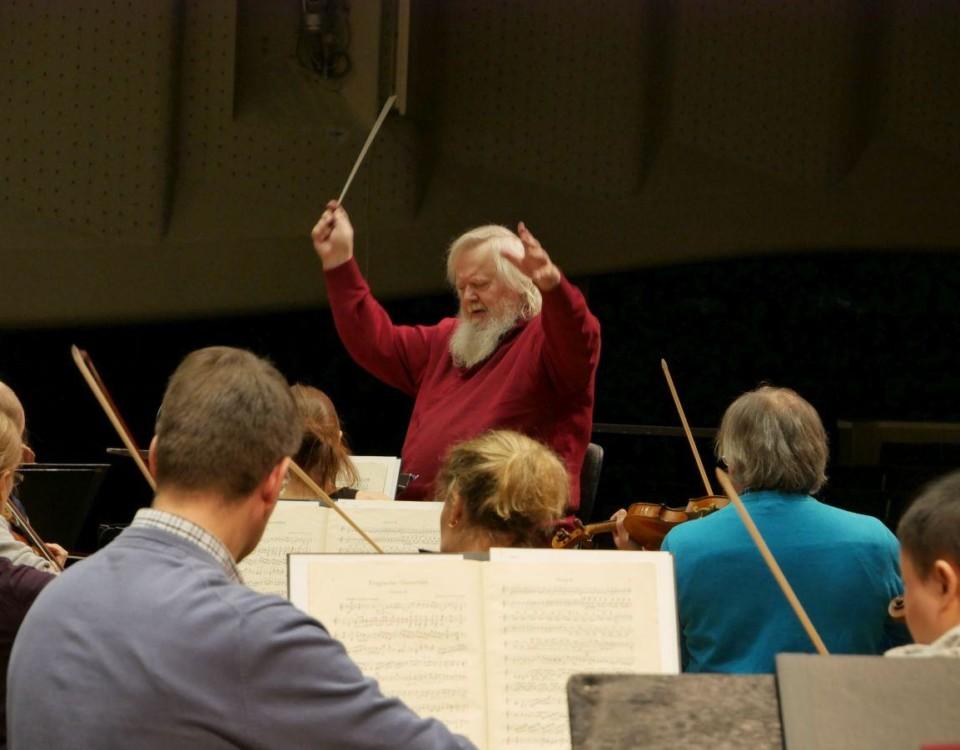 En person dirigerar en orkester.