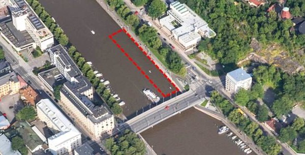 röd prickad linje som märker ut ett område på ett flygfoto över en å i en stad