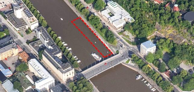 röd prickad linje som märker ut ett område på ett flygfoto över en å i en stad
