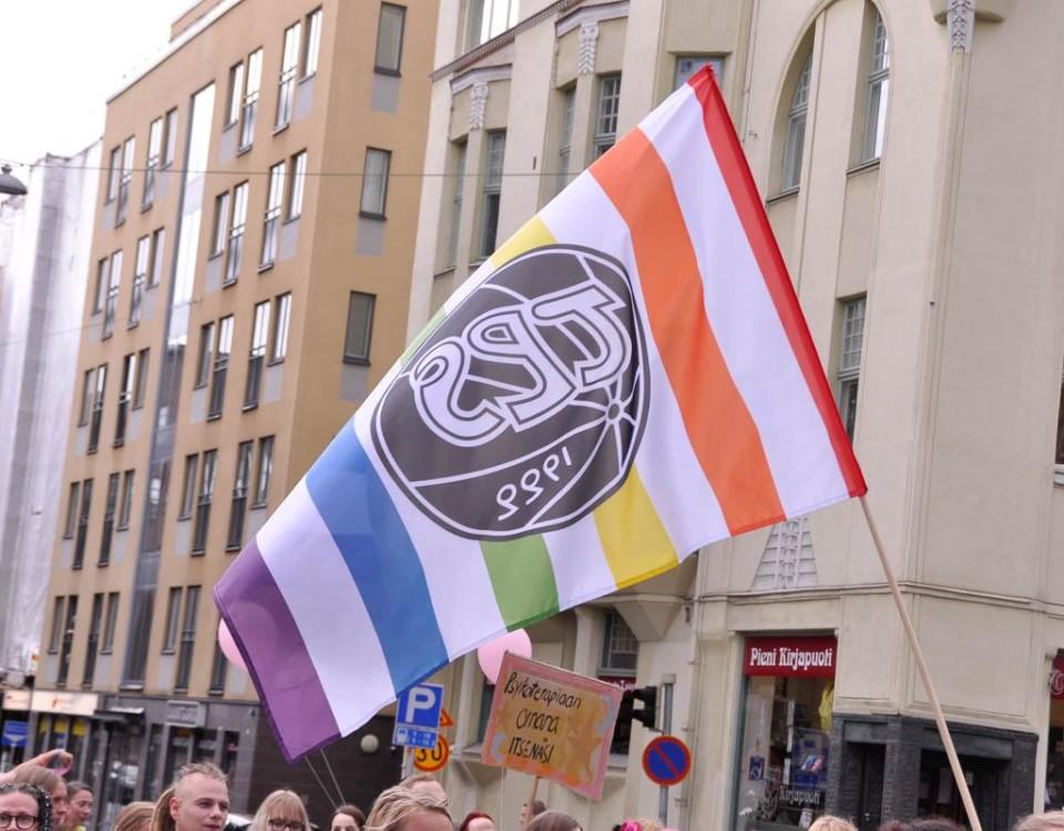 Flagga med TPS logga och regnbågens färger.