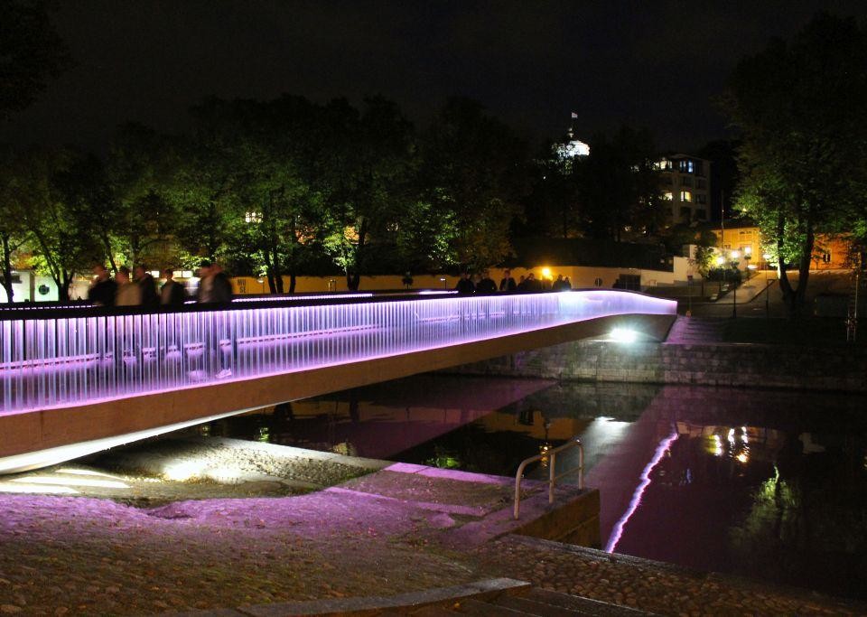 Biblioteksbron är upplyst i rosa på kvällen
