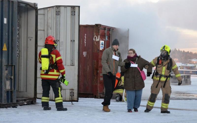 Brandmän leder folk ur rykande container