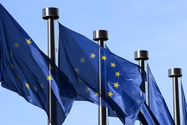EU-flaggor i rad som vajar lätt i vinden.