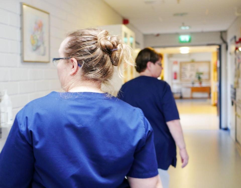 Två vårdare går i en korridor