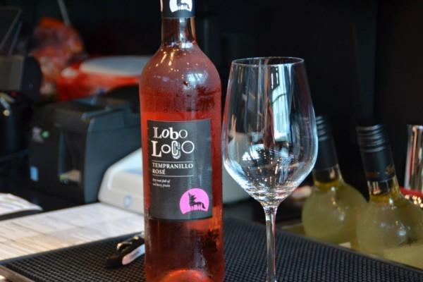En flaska rosévin och ett vinglas avbildat.