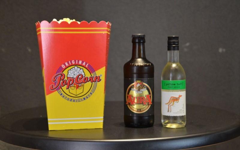 Ett paket popcorn, en öl och en liten flaska vittvin avbildat.