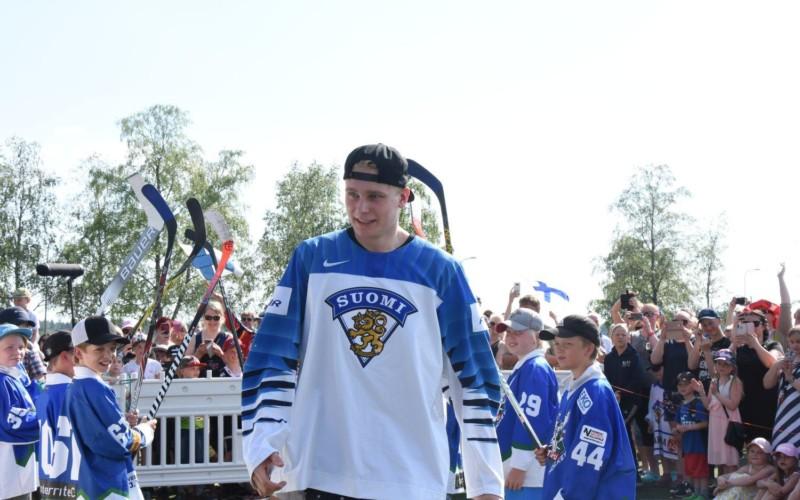 Ishockeyspelaren Kaapo Kakko iklädd Finlands vita spelskjorta stiger upp på scen på guldfesten i hans ära ordnad av Lundo kommun.