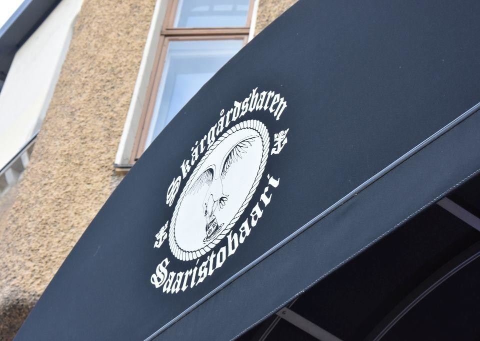 Skärgårdsbarens logo tryckt på en solmarkis utanför barens ingång