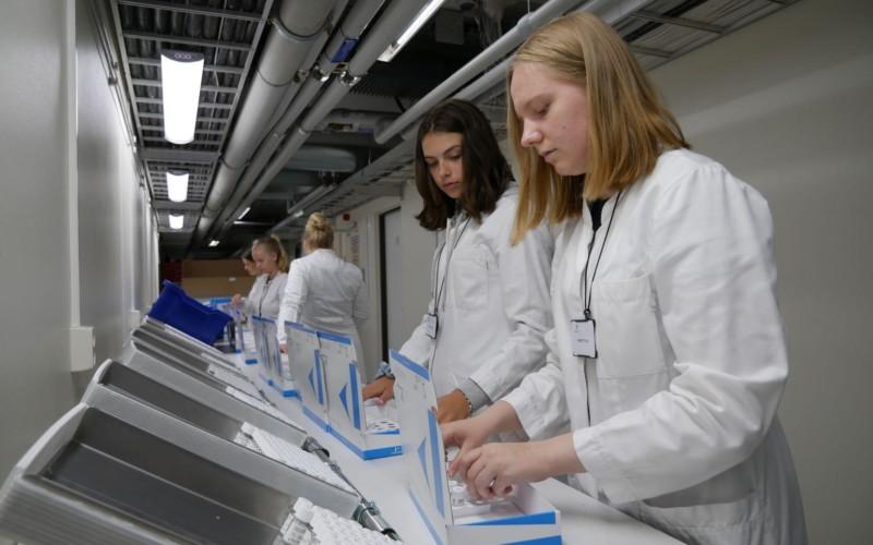 Emilia Rantala och Johanna Bergelin plockar flaskor i förpackningar.