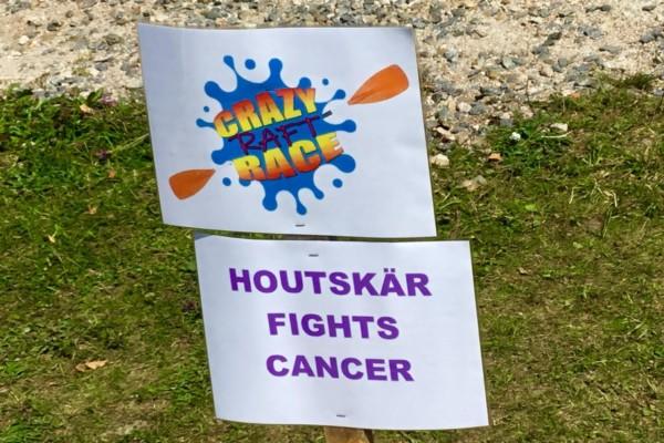 En skylt med texten "Crazy raft race" och "Houtskär fights cancer"