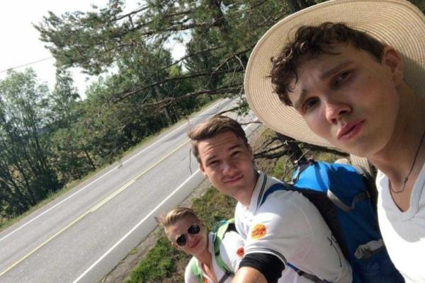 tre unga män vid en landsväg. Bilden är tagen som en selfie.