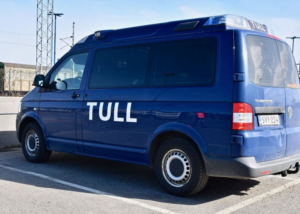 En blå bil med texten "Tull" skriven på sidan står parkerad.