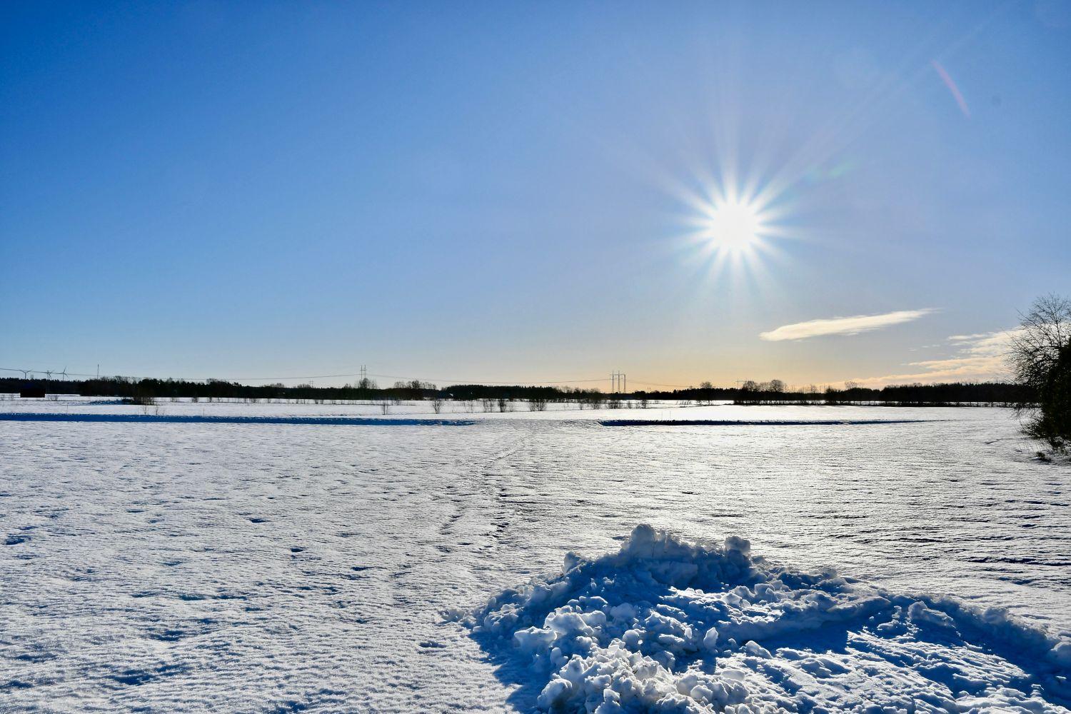 Snöigt landskap med sol.