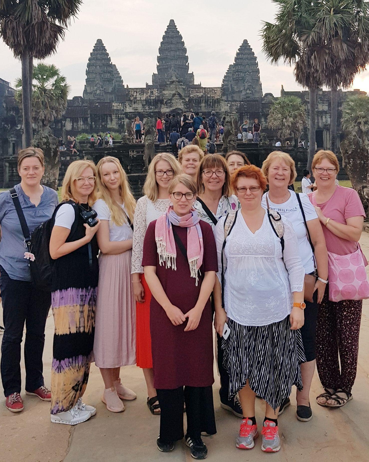 Grupp med kvinnor står framför ett tempel.