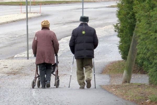 två äldre personer på promenad fotade bakifrån