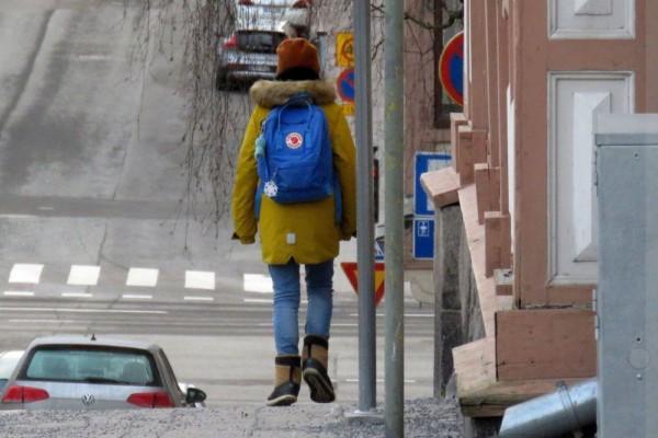 barn som går i stad med ryggsäck på ryggen