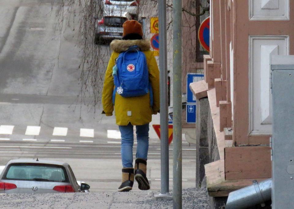 barn som går i stad med ryggsäck på ryggen
