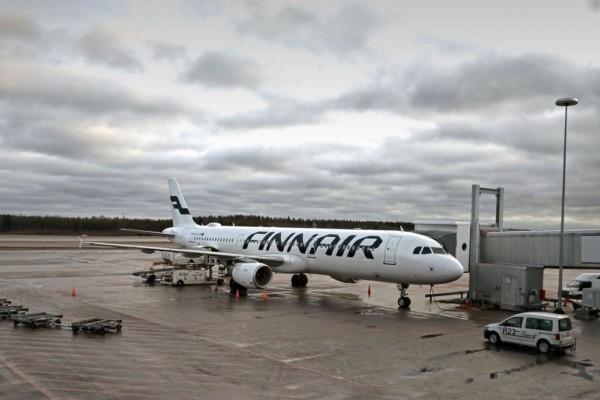 Ett Finnairflygplan står på ett flygfält i grått väder.