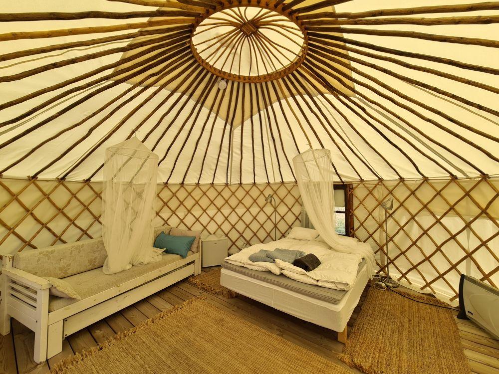 Insidan av ett stort tält med en säng och en soffa.