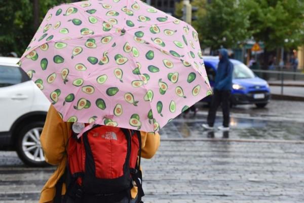 Person bär paraply i regnväöder