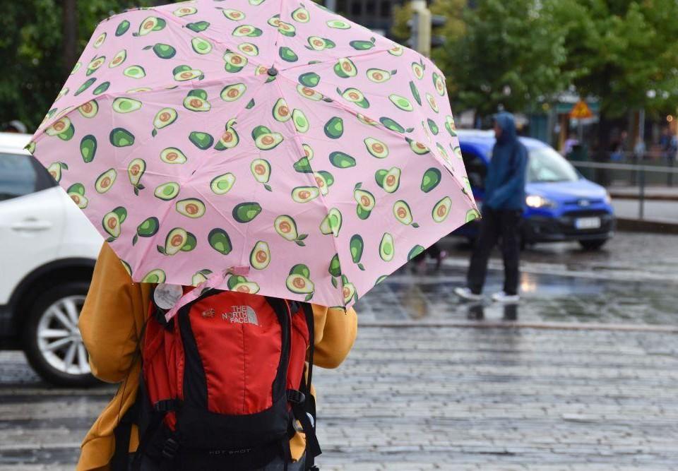 Person bär paraply i regnväöder