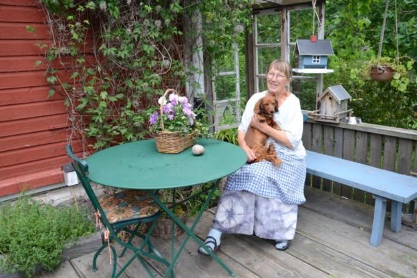 En kvinna sitter utomhus med hund.