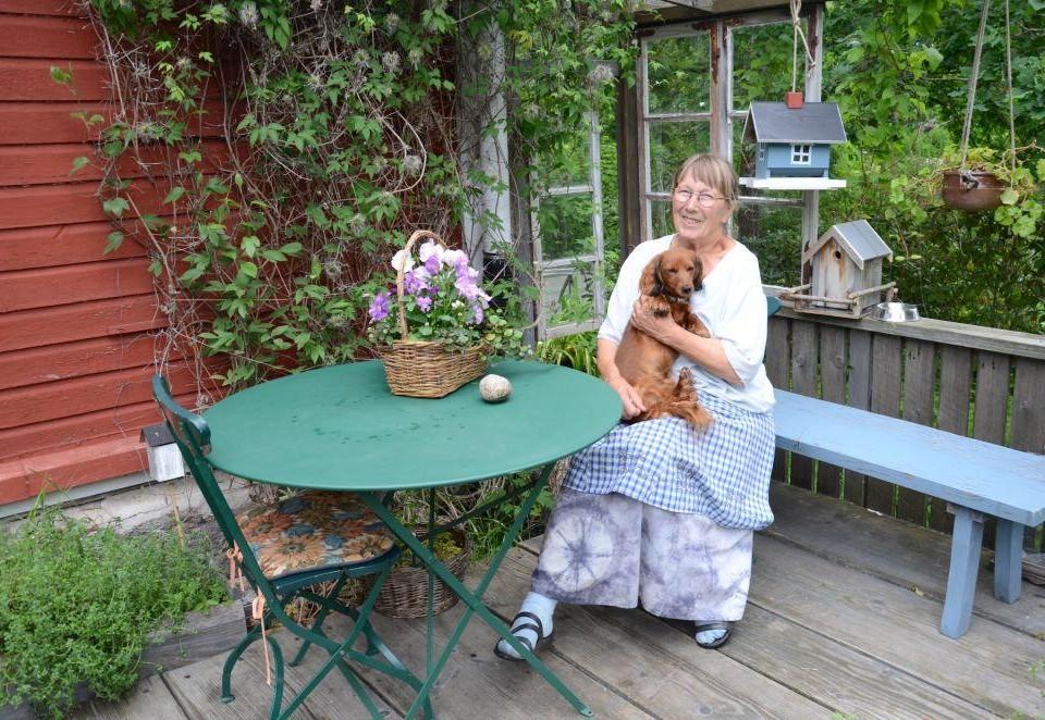 En kvinna sitter utomhus med hund.