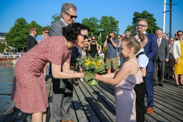 Presidentparet får blommor av två skolelever