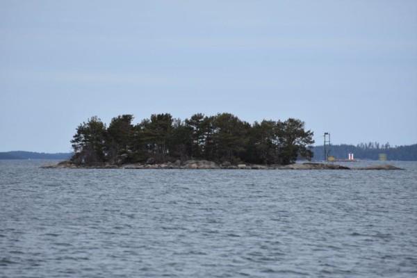 En liten trädbeklädd ö i havet.