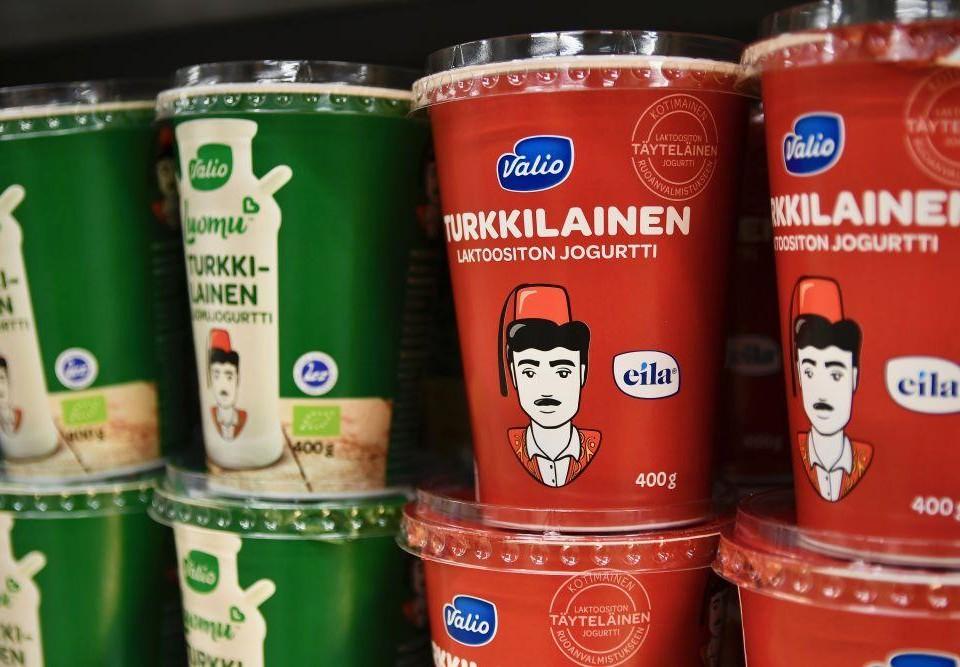 Gröna och röda burkar med turkisk yoghurt av märket Valio. Båda förpackningarna är dekorerade med en ritad turkisk man med en fez på sig.