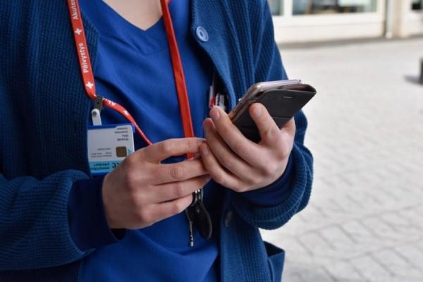 sjukvårdare håller i mobiltelefon