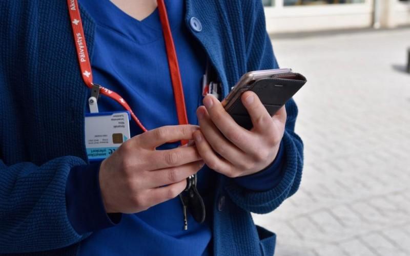 sjukvårdare håller i mobiltelefon