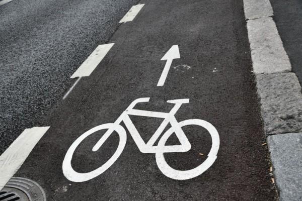 En cykelfil vid sidan av en bilväg med bilden av en cykel målad i vitt.
