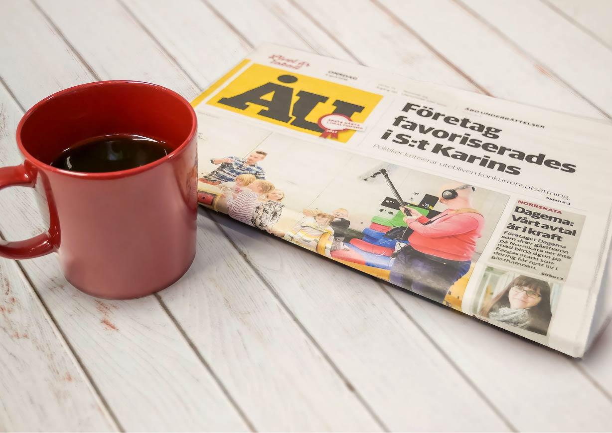 Röd kaffekopp och ett nummer av Åbo Underrättelser