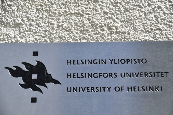 Liten skylt på byggnad med texten Helsingfors universitet på 3 språk.
