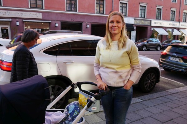 kvinna står med sin barnvagn