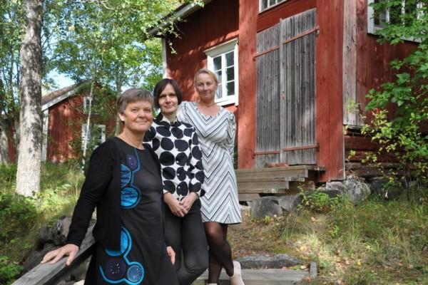 tre kvinnor vid ett gammalt hus