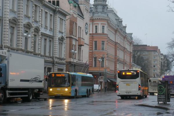 bussar i ett regnigt stadscentrum