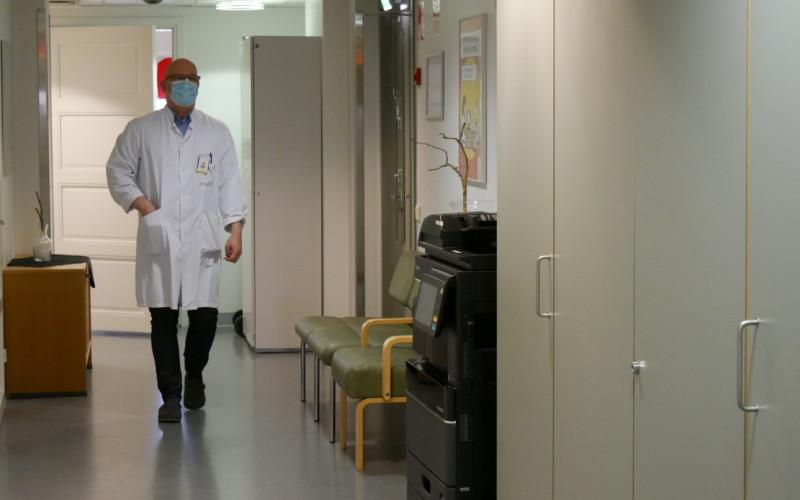 en läkare med munskydd promenerar i en korridor