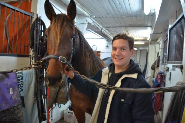 en man och en häst i ett stall