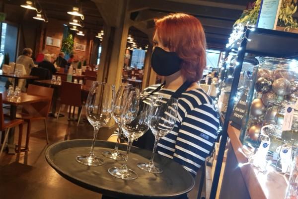 en kvinna med en bricka med glas i en restaurang