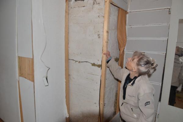 en kvinna inspekterar skador i konstruktionerna på en byggnad