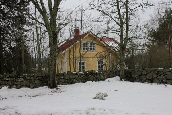 ett gult hus i ett snöigt landskap
