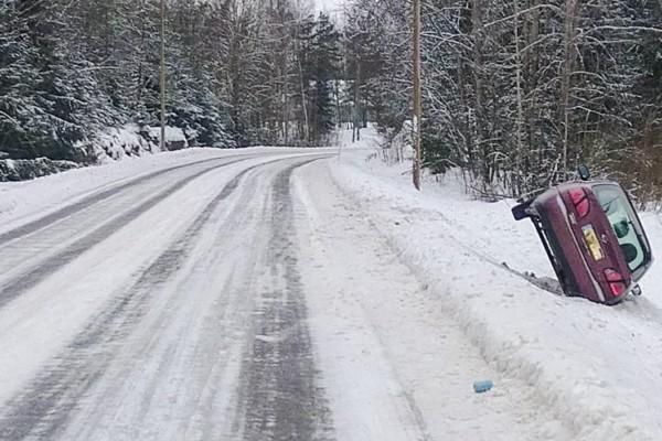 bil i diket vid landsbygdsväg med mycket snö