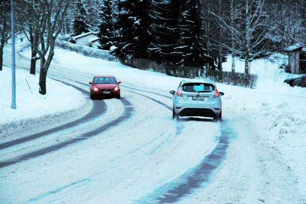 bilar kör längs väg i snöföre