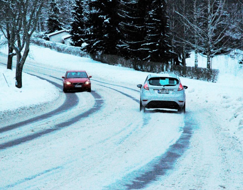 bilar kör längs väg i snöföre