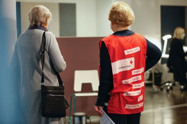 Frivillig från Röda Korset handleder kvinna